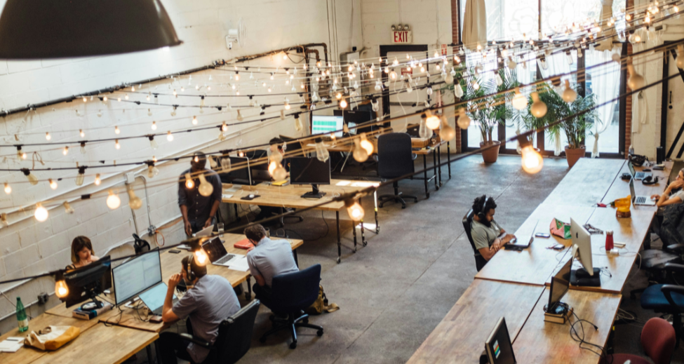 Overhead view of a small open-plan office with employees working at desks, representing a typical SME workplace